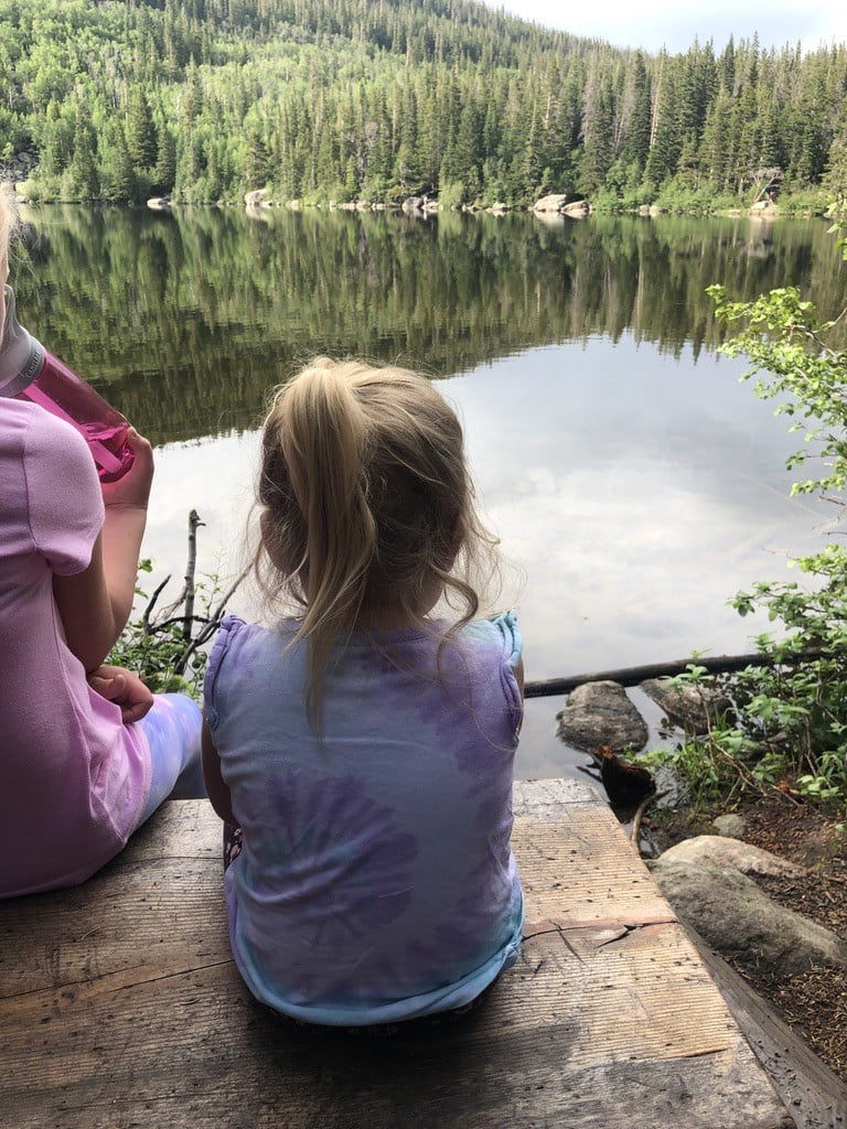 girl sitting looking at Bear Lake in Rocky Mountain National Park with kids hikes