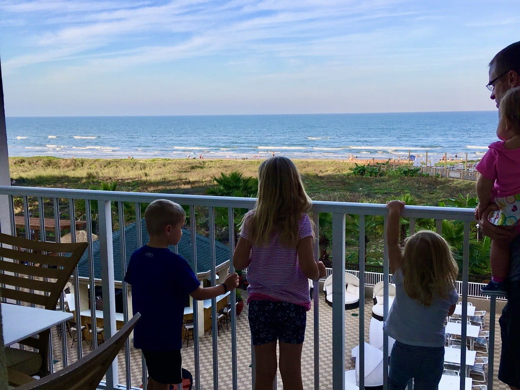 Kids looking over balcony at the ocean in South Padre Texas