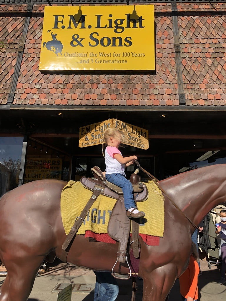 FM Light and Sons store with girl on statue horse in front, the perfect stop in Steamboat Springs in summer