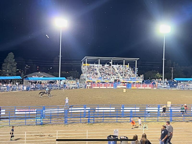 overall pic of rodeo grounds at night, tall bright lights in the back