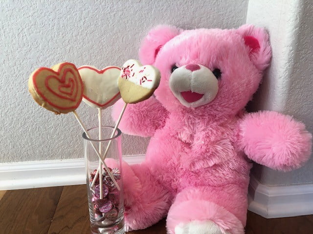 cookie bouquet decorated and next to a pink teddy bear