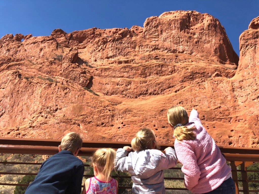 kids admiring large red rock wall in Garden of the Gods 