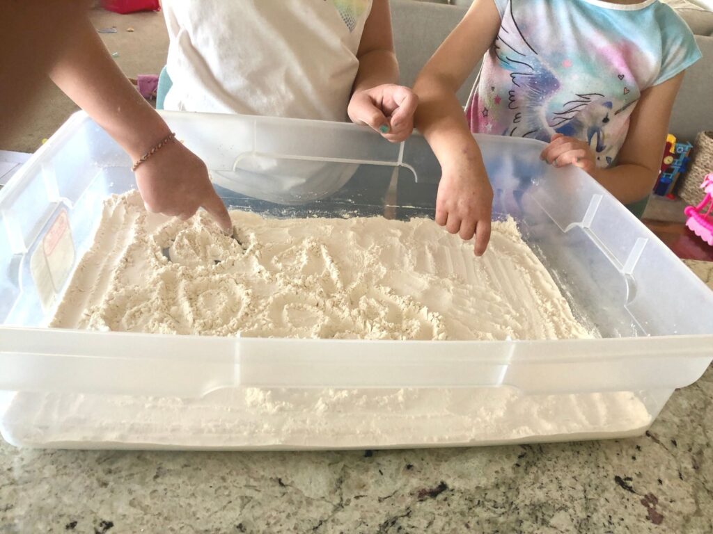 kids drawing in sand / flour