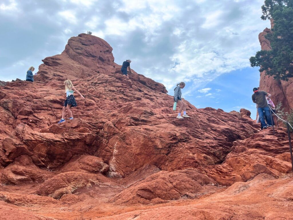 The upper loop trail at Garden of the Gods is great for kids. A cone shaped red rock formation with people sporadically walking around climbing to the top