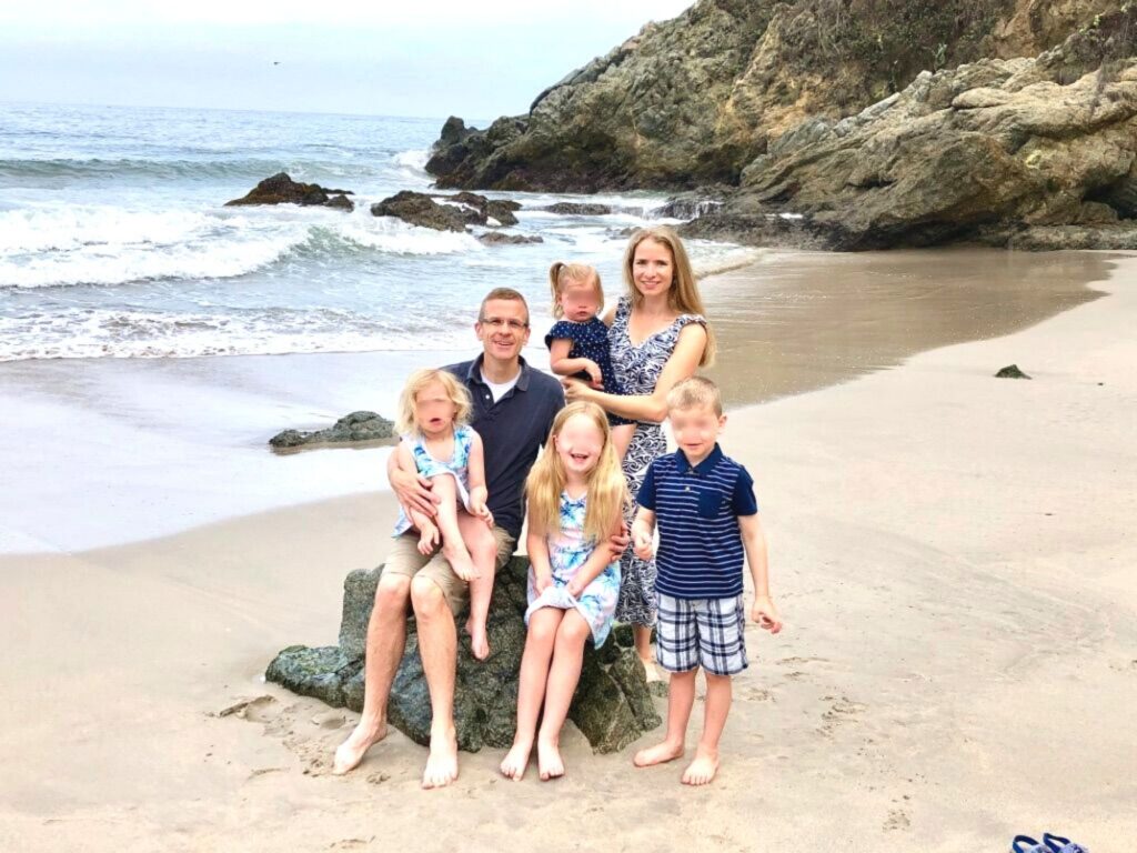 let's jet kids about us.  A family of 6 sitting on a rock in the sand along the shoreline in Mexico