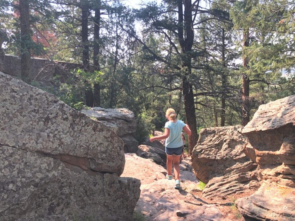 girl hiking down through rocks