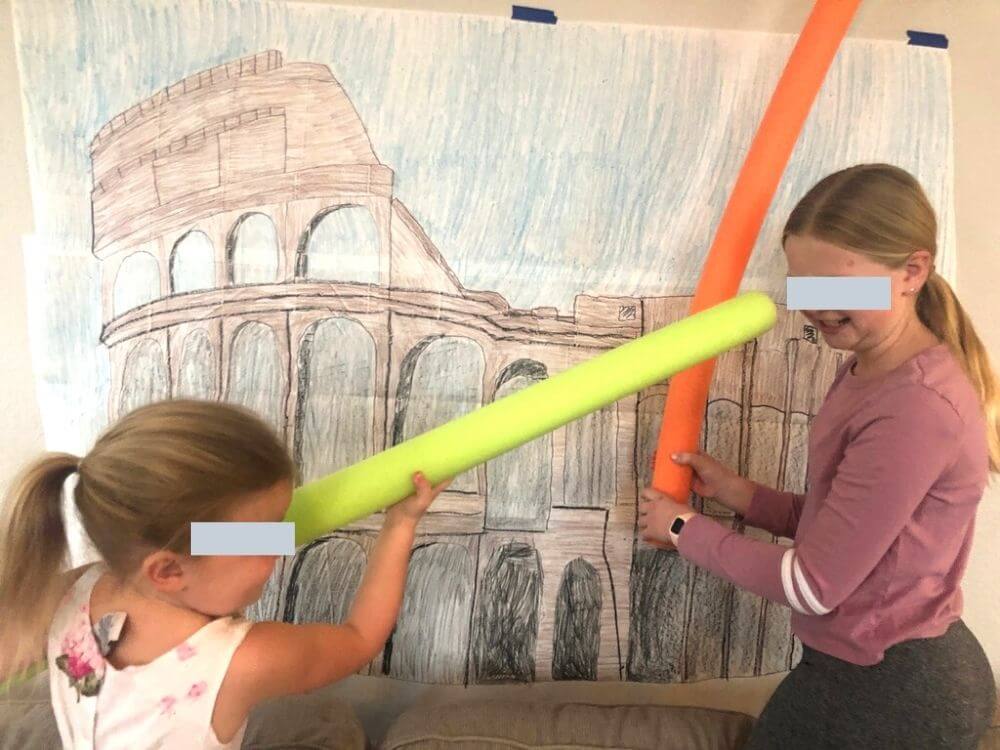 kids fighting with pool noodles in front of Colosseum picture