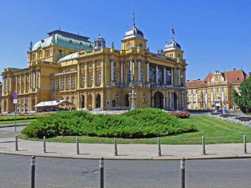 the Croatia national theater, a large yellowish-tan building