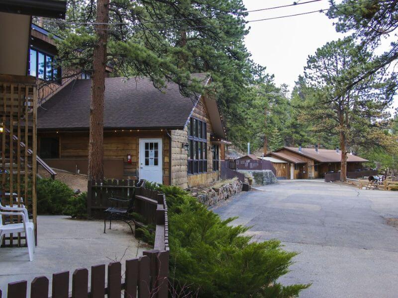 low lighting picture of a cabin on a road with trees all around