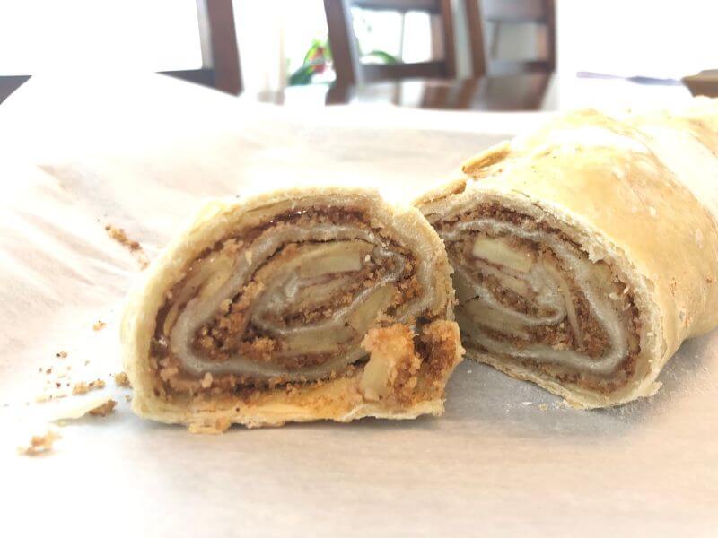 thin pastry rolled with filling and walnuts, cut in half to see center.