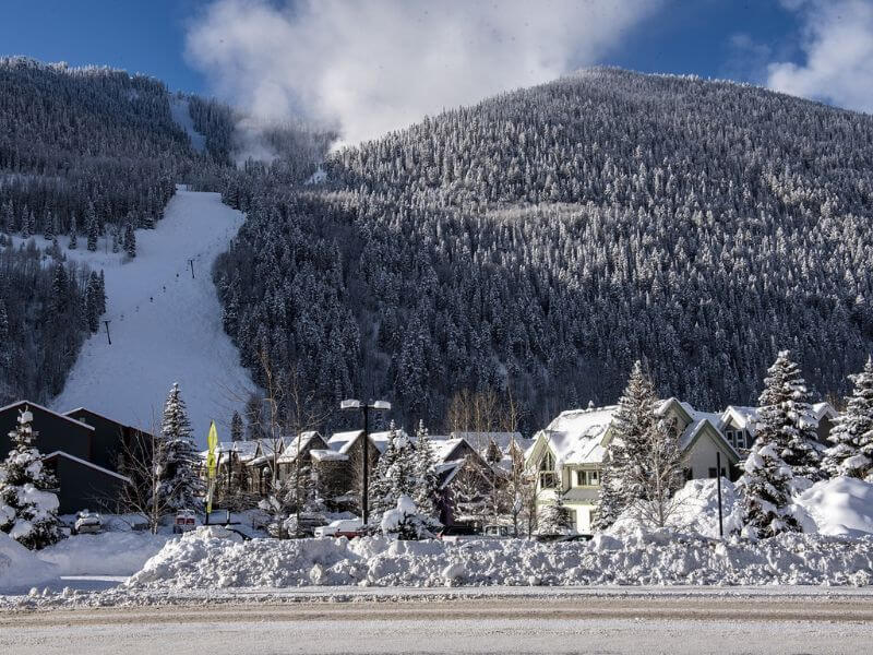 snowy mountain town with ski run in the back