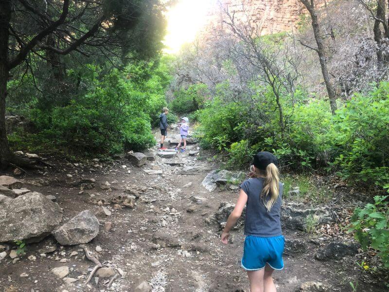 kids walking on dirt trail covered in rocks at Hanging Lake