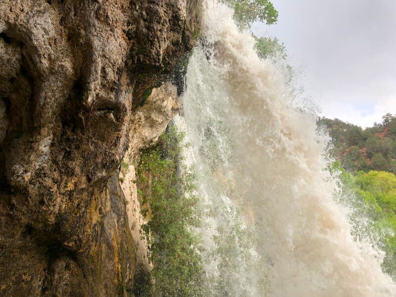 behind a powerful waterfall at Rifle Falls State Park