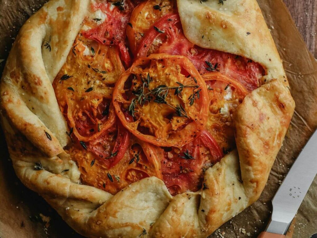 sliced tomatoes baked into a crust that is open on top but twists around the edges