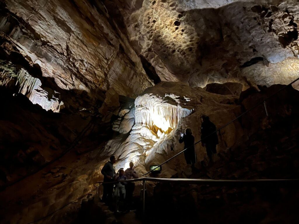 the darkest part of Carlsbad Caverns. No lights except for a bright light shining on a specific formation on the side.