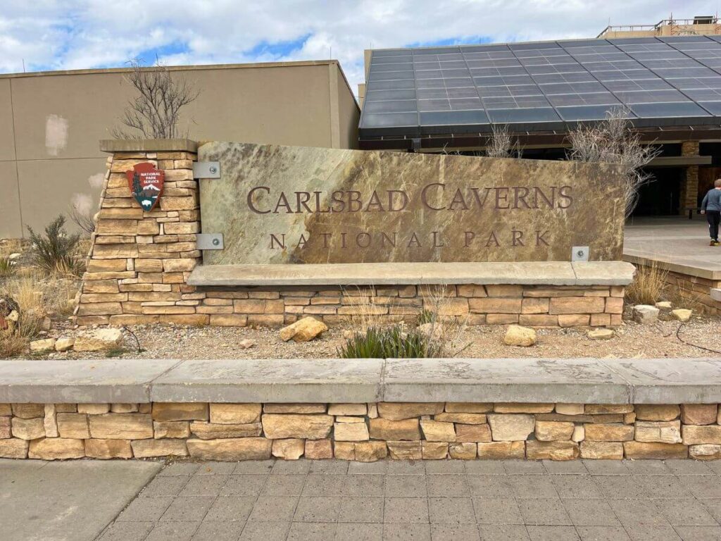 visitor center exterior at Carlsbad Caverns National Park, official national park sign in foreground and building in back