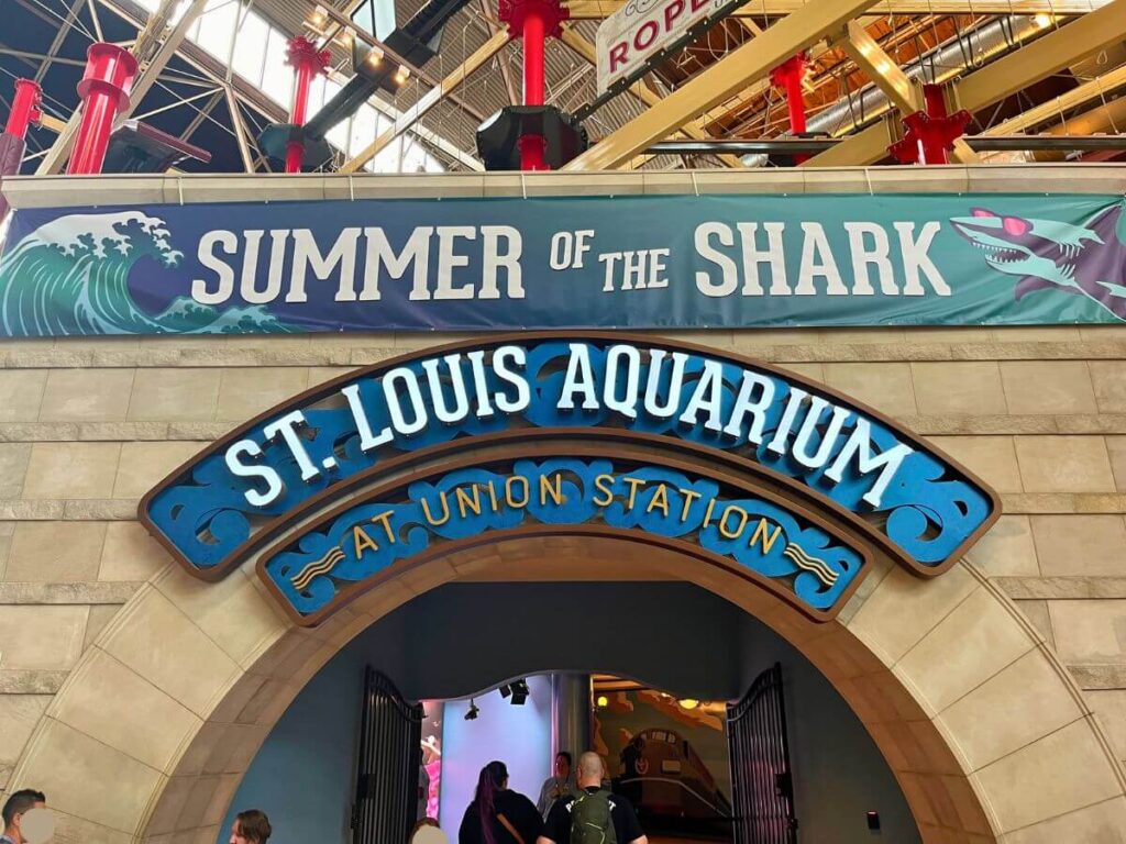 Close up of Entrance to St. Louis Aquarium. Arched entryway with words "St. Louis Aquarium" over the arch. Above is a banner that reads "Summer of the Shark"