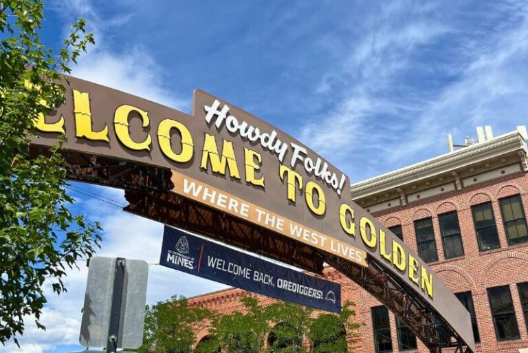 Looking up at a brown arch with the words "Welcome to Golden" on it