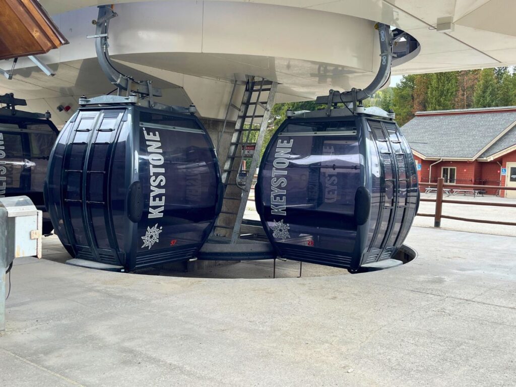 the Keystone Resort gondolas at the loading area. Two gondolas are close together as they come around the corner