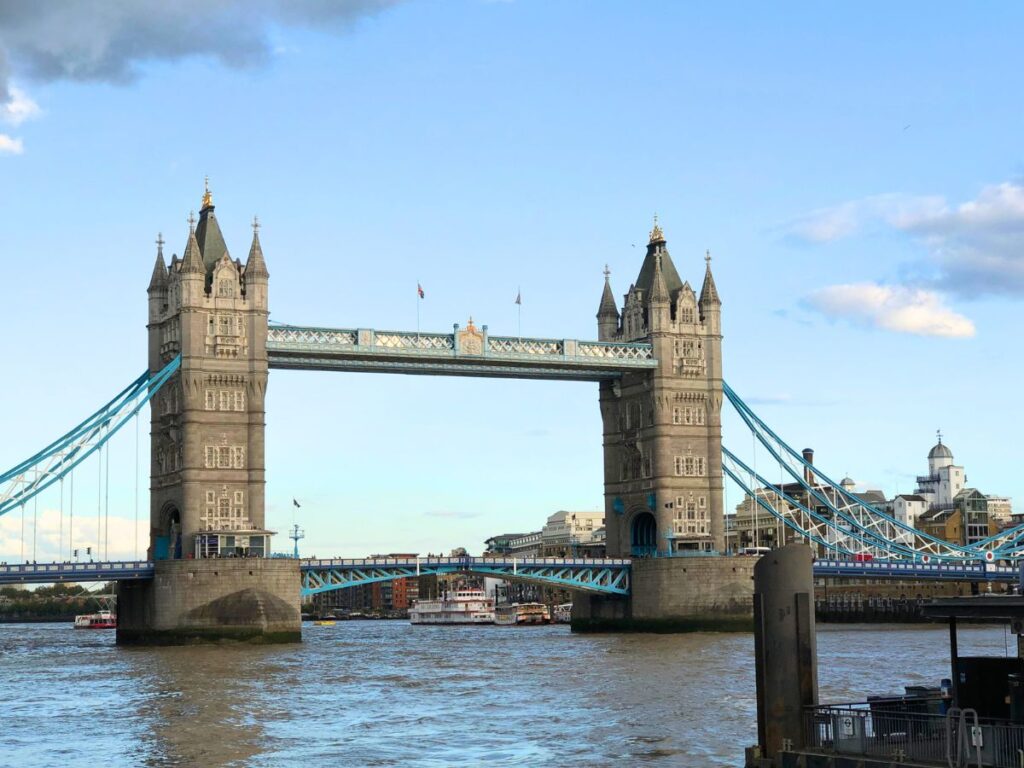Tower Bridge in London.  Two tall skinny tower spires with a foot bridge going across the top.  It sits over a river.  London is a great travel inspired baby name