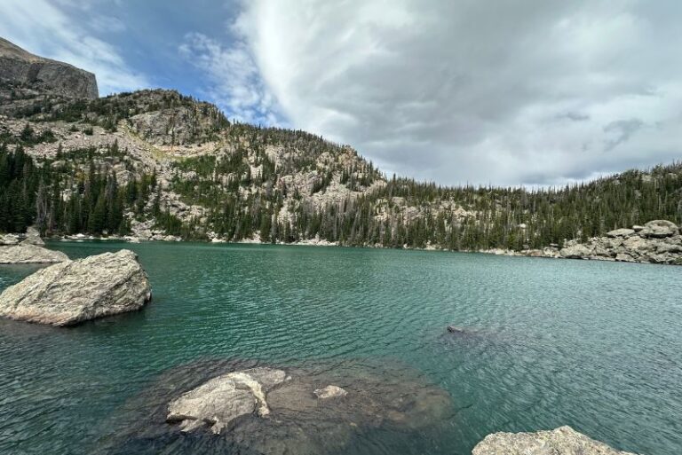 greenish turquoise waters at Lake Haiyaha in Rocky Mountain National Park. A mountain sits behind and large boulder are in the water