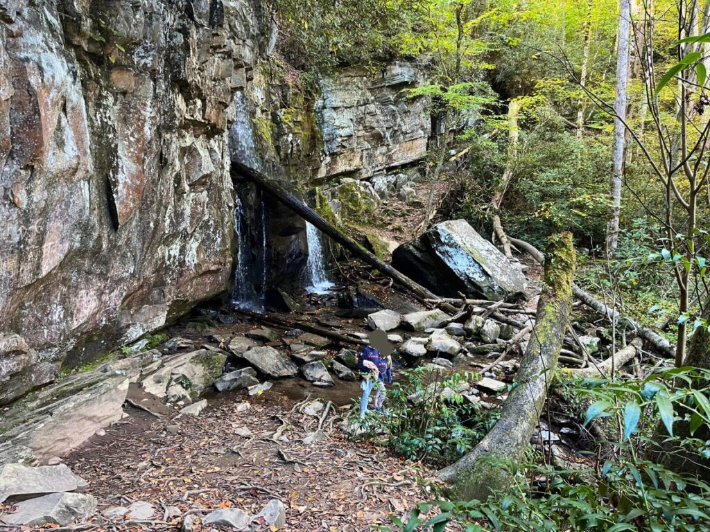 Coming into view of Baskins Creek Falls from the end of the trail. Lots of rocks and green trees