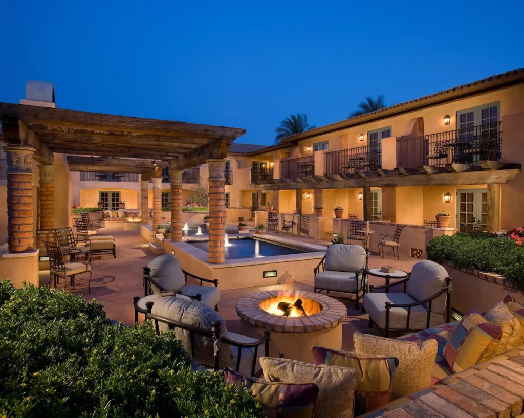 scottsdale resort.  Exterior is lit up at night, with a pool in the center and a firepit in the foreground